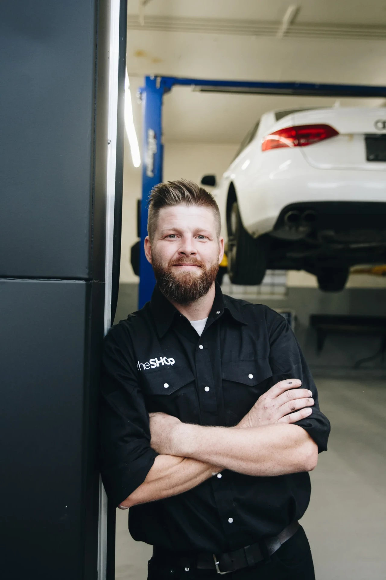 Travis, owner and certified Automotive Service Technician, in the bay at The Shop